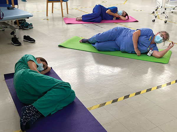 healthcare profeissionals in srcubs on yoga mats